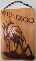 a wooden plaque with a carved design depicting a deer or elk.
