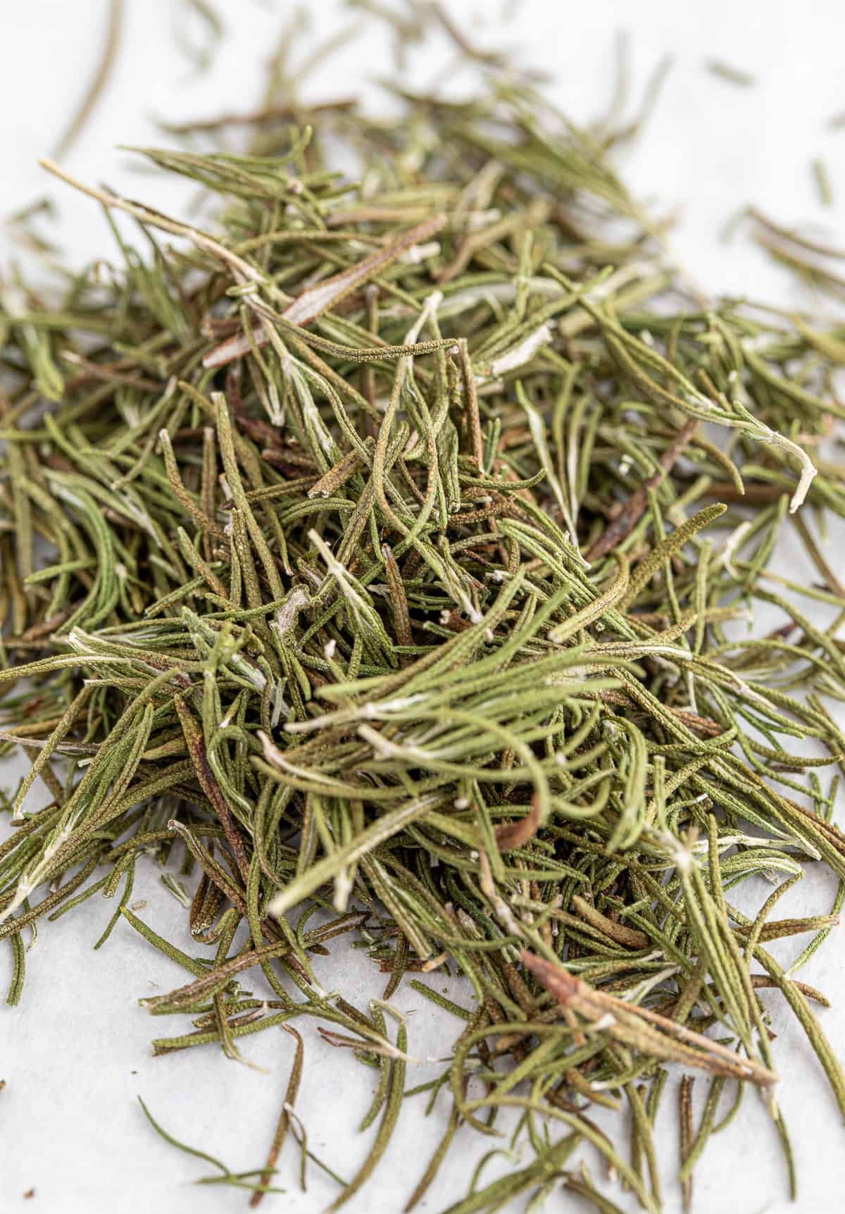 Pile of dried rosemary on a white background